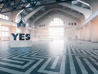 Grote sculptuur met het woord 'JA' in een lege, moderne ruimte met een lichte vloer en veel natuurlijk licht.