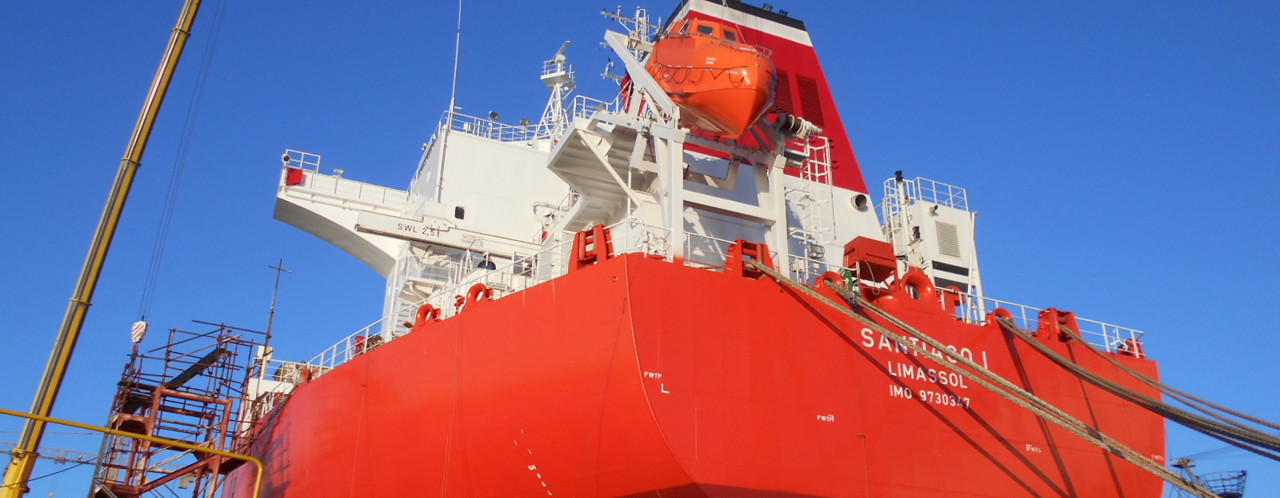 Red cargo ship named 'SANTANDER' with an orange lifeboat, set against a blue sky.