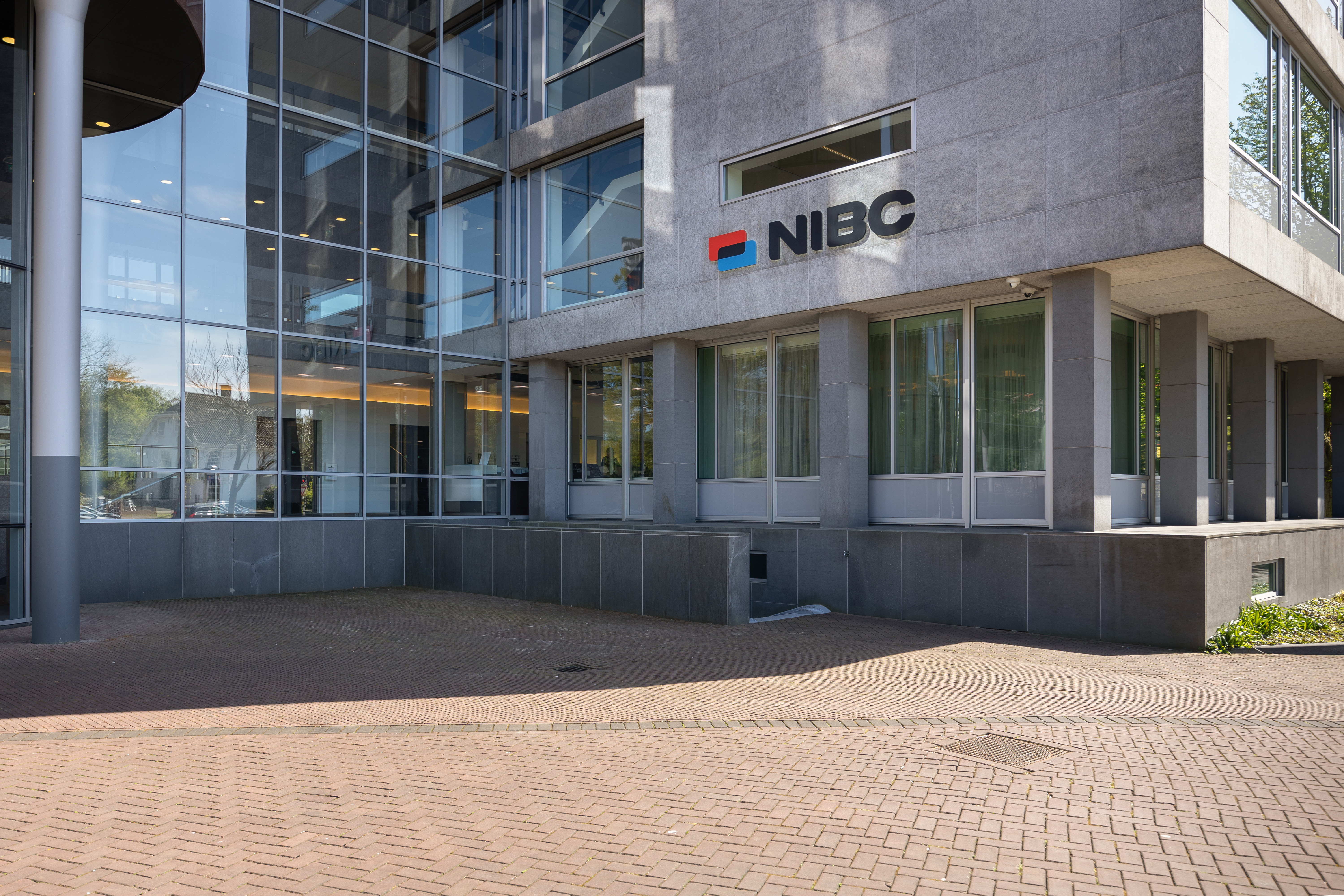 Main entrance of the NIBC office featuring large windows and the NIBC logo on the wall.