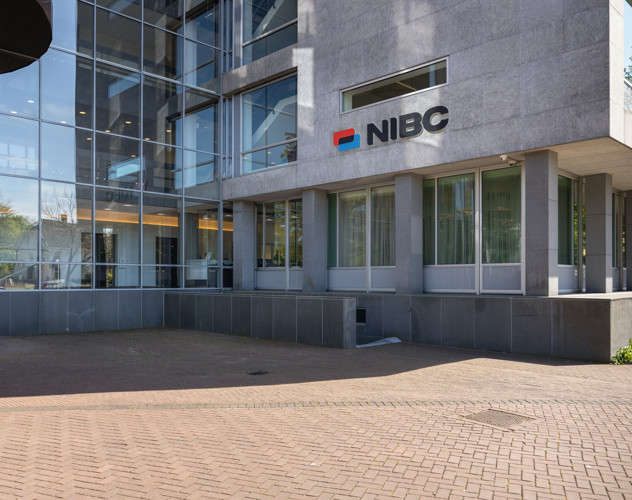 Main entrance of the NIBC office featuring large windows and the NIBC logo on the wall.