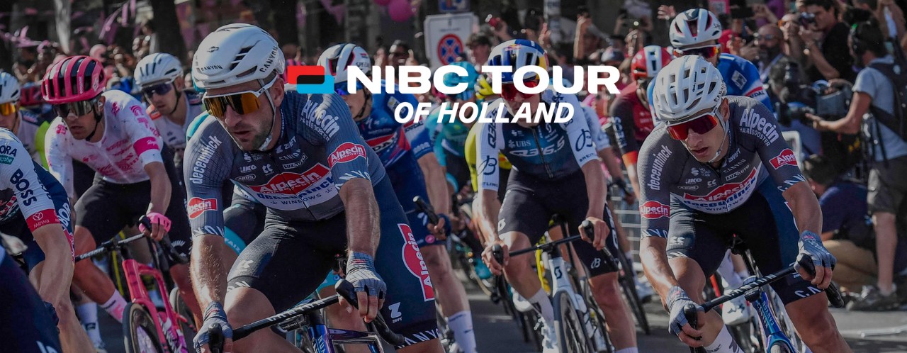 A group of cyclists in action during the NIBC Tour of Holland, with spectators along the roadside.